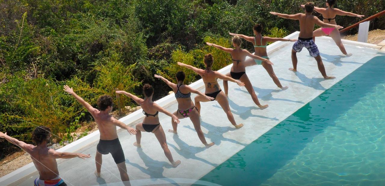 A yoga class practising along the edge of the pool
